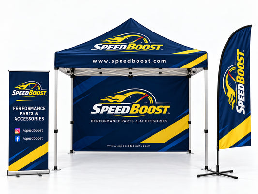 A SpeedBoost branded outdoor pop-up canopy tent with matching vertical banner and flag on a light gray studio background. The canopy and banners feature blue, yellow, white, and black graphics, including the SpeedBoost logo, website text, and checkered flag motifs.